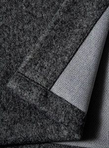 Macro view showing gray wool-like fabric with honeycomb mesh lining and fine stitching