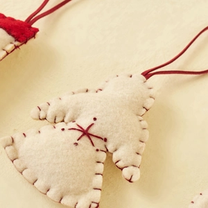 Handmade red and white felt angel Christmas tree ornaments with decorative stitching