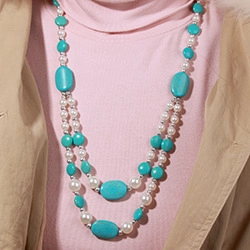 Close-up of double-layer necklace with large oval turquoise beads and white faux pearls