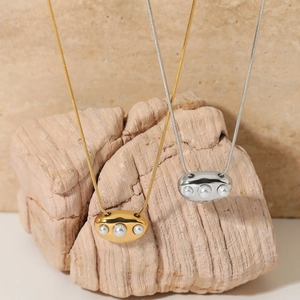 Collier pendentif perle minimaliste avec chaînes serpent or et argent sur pierre
