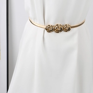 Close-up of golden elastic spring belt with three exquisite rose flower ornaments
