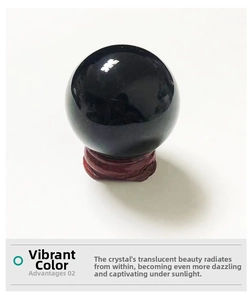 Close-up of polished black obsidian crystal ball on a carved wooden display pedestal