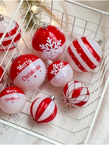 Détail de boules de Noël rouges et blanches avec flocons et rayures dans un panier blanc