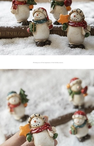 Close-up of hand-painted resin snowman figurines for festive tabletop scenery decoration