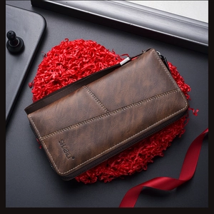 Dark brown leather long wallet with zipper and wristlet on festive red gift decor