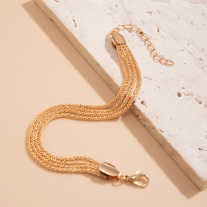 Detail of golden multilayer fine chain bracelet with lobster clasp and extender