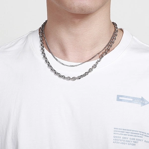 Détail d'une double chaîne hip hop argentée portée sur un mannequin en t-shirt