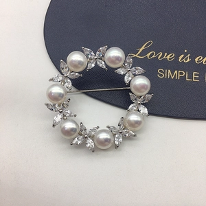 Detail of floral brooch featuring natural pearls and marquise-cut zircons in silver finish