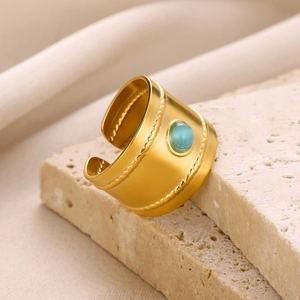 Macro shot of gold stainless steel ring featuring green cat eye stone and braided edges