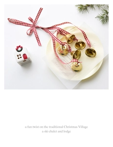 Close-up of golden Christmas metal bells with red and white checkered ribbons