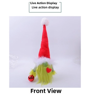 Detail of Christmas gnome plush with red hat and green fur holding a shiny heart ornament