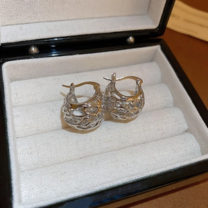 Detailed close-up of silver hollow woven basket hoop earrings in a black jewelry box