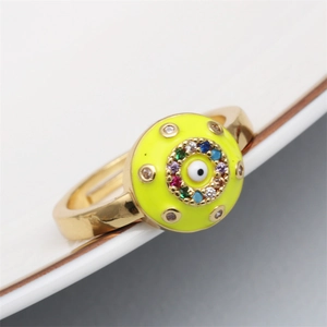 Macro view of adjustable gold ring with yellow enamel, evil eye, and colorful crystals