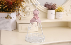Detail of pink velvet jewelry stand with white metal hooks and circular mesh base