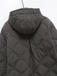 Detailed close-up of diamond quilted pattern and hood seam on women casual jacket