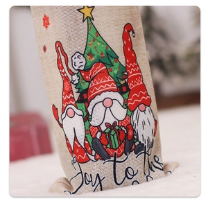 Detail view of burlap Christmas wine bottle cover with Joy to the world print and gnomes