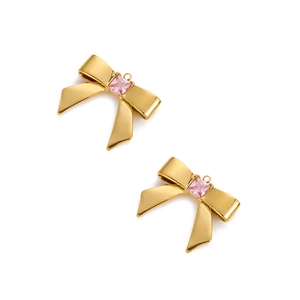 Detailed view of gold plated bow charm with a square pink gemstone for DIY jewelry