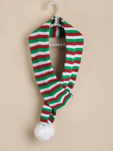 Detail of red and green striped knit dog scarf with pom-poms for Christmas