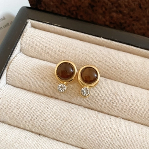 Detailed close-up of vintage tiger eye stud earrings with silver rhinestone accents