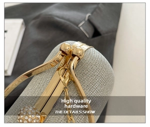 Gros plan sur la quincaillerie dorée et le tissu pailleté argenté d'une pochette de luxe
