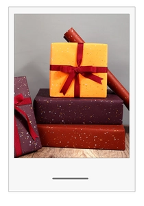 Detail of gold foil gift wrapping paper in various colors with elegant red mesh ribbons