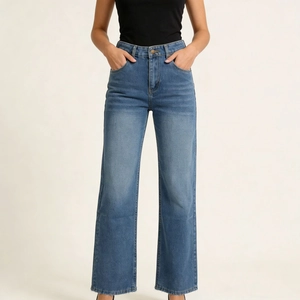 Detail showing the vintage washed denim texture and high-waist fit of blue straight jeans