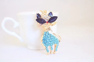 Detailed view of cat keychain with blue crystals and sparkling rhinestones on gold metal