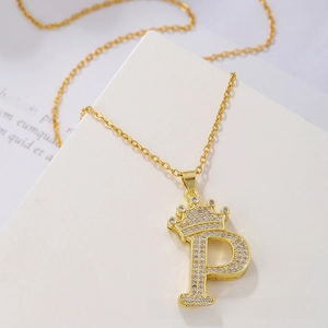 Detailed view of gold crown letter P pendant necklace with sparkling cubic zirconia pavé