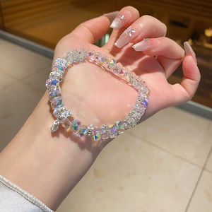 Detailed macro view of multifaceted iridescent crystal beads and heart-shaped diamond charm