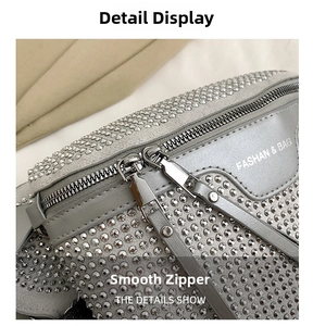 Detailed macro view of sparkling rhinestone embellishment and dual metal zippers on silver bag