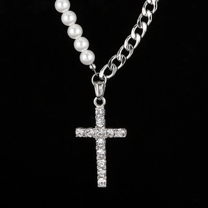 Détail macro du collier chaîne cubaine argentée avec perles et pendentif croix serti