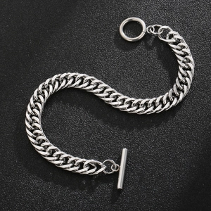 Detailed view of silver Cuban link bracelet with OT toggle clasp on black surface