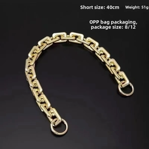 Detail of 40cm gold acrylic handbag chain strap with round spring clasps on black background