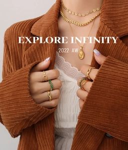 Detail of 18K gold plated hollow chain rings and emerald zircon necklaces on model