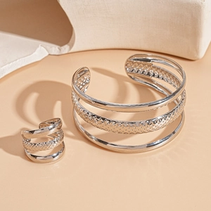 Detailed view of silver layered open bangle and ring set with metallic texture