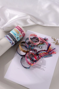 Close-up of colorful handmade woven bohemian friendship bracelets on silk background