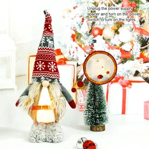 Illuminated Christmas gnome doll with knit hat and LED lights on a holiday tree backdrop