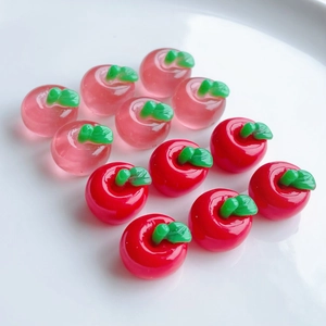Macro view of mini resin apple beads in translucent pink and solid red colors