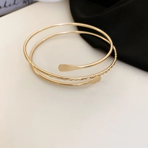 Detail of gold multi-layer wrap bracelet featuring mirror polish and hammered texture finish