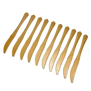 Close-up of 12 disposable gold plastic knives with elegant scalloped handle texture