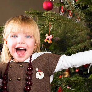 Close-up of a child wearing a cute Santa Claus brooch pin as a festive Christmas decoration