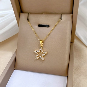 Star-shaped gold necklace with sparkling crystals presented in a beige gift box