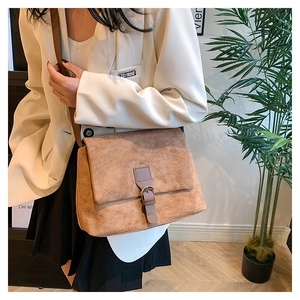 Detailed close-up of brown frosted suede crossbody bag with vintage metal buckle strap