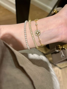 Detail of 18K gold plated star bracelet set with zircons and pearls on wrist