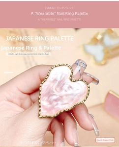 Close-up of a pink heart-shaped resin nail art palette ring with gold trim and agate texture