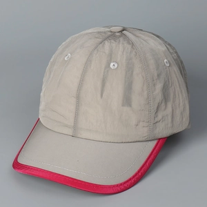 Détail d'une casquette de baseball gris clair à séchage rapide avec liseré rose fluo