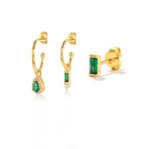 Detailed view of three gold-tone earrings with green crystals and white zircons