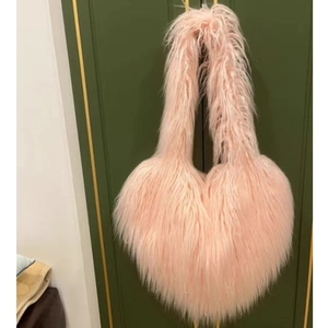 Detail of pink heart-shaped fuzzy faux fur shoulder bag with long plush texture
