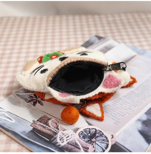 Macro shot of an open animal-shaped wool felt coin purse with zipper and black lining