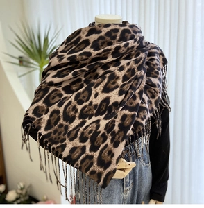 Close-up of leopard print scarf with long fringe detail on a mannequin